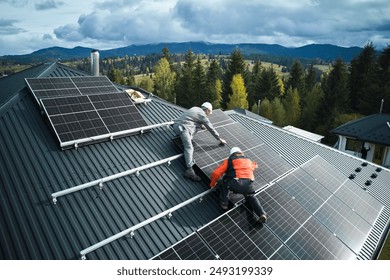 Electricians building photovoltaic solar module station on roof of house. Men technicians in helmets installing solar panel system outdoors. Concept of alternative and renewable energy. Aerial view. - Powered by Shutterstock