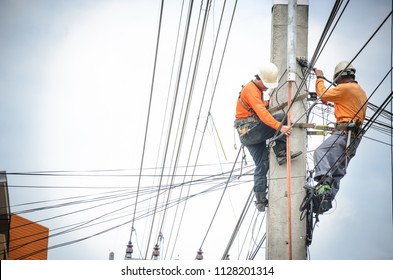 Electricians are climbing on electric poles to install and repair power lines.
