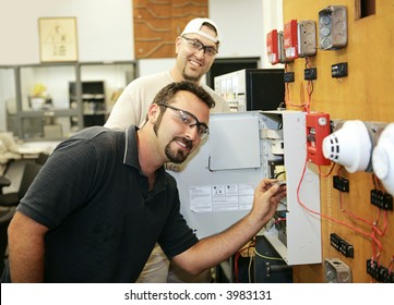 Electricians Learning To Repair Fire Alarm Systems In A Vocational Education Training Class.