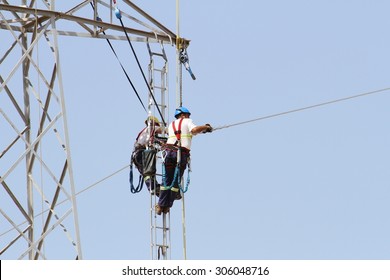 Electricians Repairing High Tension Tower Cable