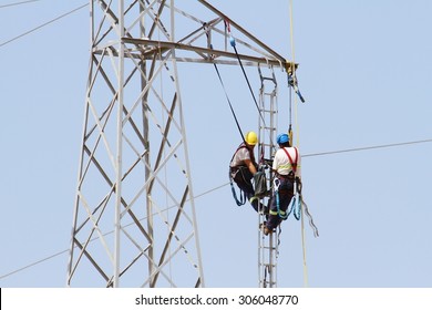 Electricians Repairing High Tension Tower Cable