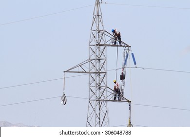 Electricians Repairing High Tension Tower Cable