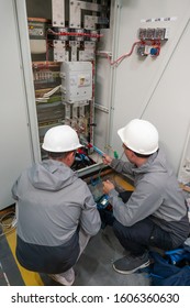 Electricians Take Measurements, Electric Meter. Worker In Uniform Takes Measurements. Electric Energy Quality - The Degree To Which Electric Energy Parameters Correspond To Their Established Values