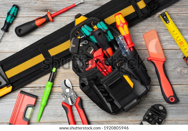 Electrician\'s tools on the table. An laser tape\
measure, screwdrivers, tongs, construction tape measure, and a\
level are spread out on the table. Top\
view