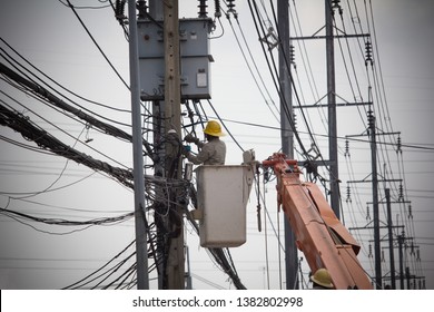 Electricians Wiring Cable Repair Services.
Technician Checking Fixing Broken Electric Wire On Pole.
Electricity Power Utility Worker In Crane Truck Bucket Fixes High Voltage Power Transmission Line.