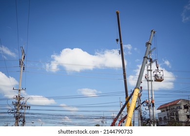 Electricians Wiring Cable Repair Services.
Technician Checking Fixing Broken Electric Wire On Pole.
Electricity Power Utility Worker In Crane Truck Bucket Fixes High Voltage Power Transmission Line.
