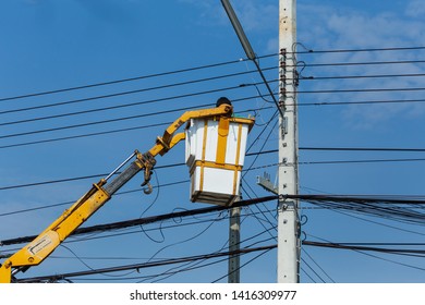 Electricians Wiring Cable Repair Services,worker In Crane Truck Bucket Fixes High Voltage Power Transmission Line,pole And Basket With Big Crane.