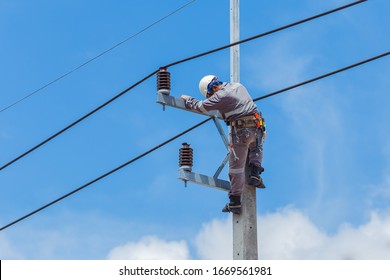 Electricians Wiring Cable repair services,worker in crane truck bucket fixes high voltage power transmission line,setting up the power line wire on electric power pole,Soft focus,selective focus.