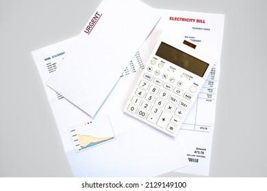 Electricity Bill, Bank Statement, Calculator And Postal Envelope With The Word Urgent As A Concept Of Rising Prices And Debt