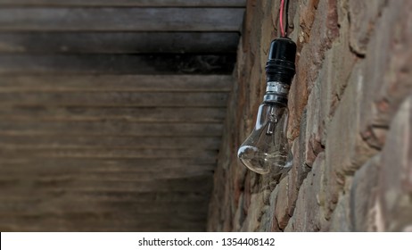 An electricity bulb hanging with the wall with no electricity in an Indian Village.