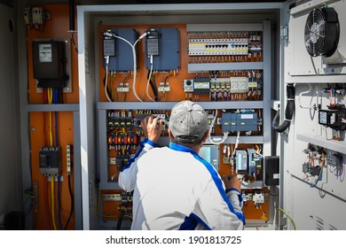 Electricity Distribution Box, Male Electrician Working On The Electrical Distribution Grid