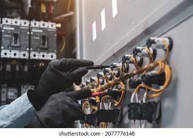 Electricity And Electrical Maintenance Service, Close-up Circuit Breaker Has Engineer Using Measuring Equipment Checking Electric Volt At Terminal Block And Cable Wiring Main Power Distribution Board.