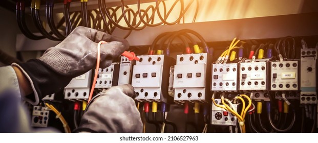 Electricity And Electrical Maintenance Service, Close-up Circuit Breaker Has Engineer Using Measuring Equipment Checking Electric Volt At Terminal Block And Cable Wiring Main Power Distribution Board.