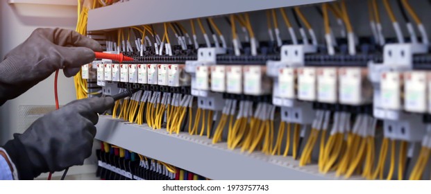 Electricity And Electrical Maintenance Service, Engineer Checking Electric At Circuit Breaker And Cable Wiring System For Repairing Main Power Distribution Board.