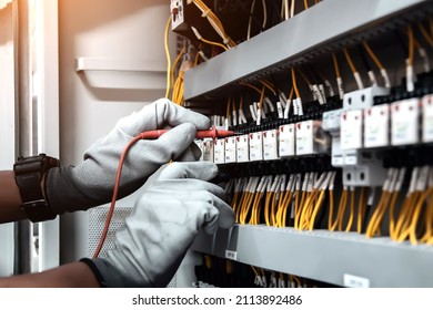 Electricity and electrical maintenance service, Engineer using measuring equipment tool checking electric current voltage at circuit breaker terminal and cable wiring main power distribution board.