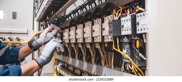 Electricity and electrical maintenance service, Engineer hand holding AC voltmeter checking electric current voltage at circuit breaker terminal and cable wiring main power distribution board. - Shutterstock ID 2159213089