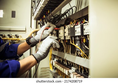 Electricity and electrical maintenance service, Engineer hand holding AC voltmeter checking electric current voltage at circuit breaker terminal and cable wiring main power distribution board. - Shutterstock ID 2174208719