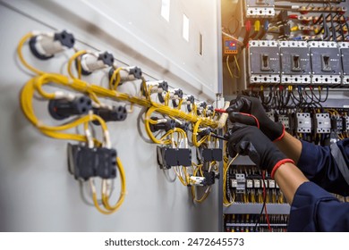 Electricity and electrical safety maintenance service system, Technician hand checking electric current voltage at circuit breaker terminal and cable wiring in main power distribution board.