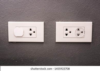 Electricity Outlet On The Wall That's Covered With Safety Plugs. Protection Baby Form Playing With Plug. Safety First Concept. Covering Plug Holes Of The Surge Protector.