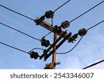 Electricity pole in Indonesia with power line cables against sky