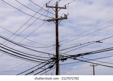 Electricity pole with many electrical cables. Complex power grid wooden poles connecting and distributing electricity and TV signals.