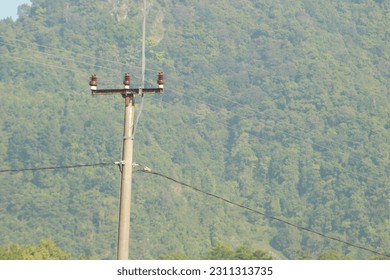 electricity pole with very green hills background in indonesia - Shutterstock ID 2311313735