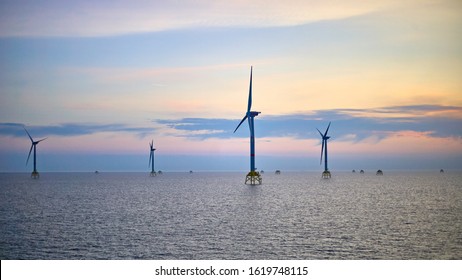Electricity production by offshore wind turbine farm in the sea. Clean wind energy production in the sea.