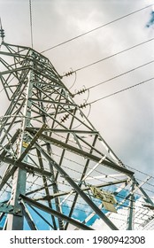 Electricity pylon from below with clouds and blue sky.