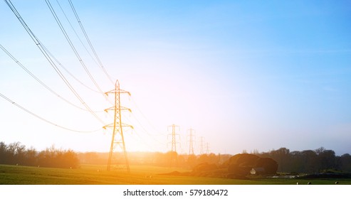 Electricity pylon in a field with blue sky.