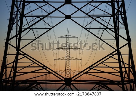 Electricity pylon (Strommasten) also overhead line pylon. Construction forms windows. Winter evening.