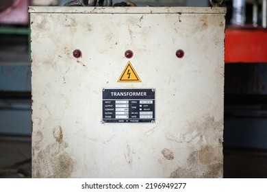 Electricity transformer with high voltage caution safety sign and specification tag on the control panel cover. Industrial equipment object photo.