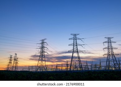 electricity transmission pylon silhouetted against blue sky at dusk - Shutterstock ID 2176900011