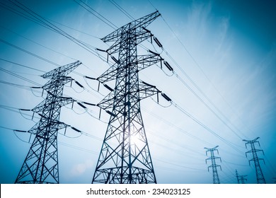 electricity transmission pylon silhouetted against blue sky at dusk  - Shutterstock ID 234023125