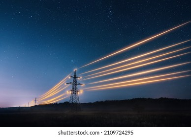 Torres de transmisión de electricidad con alambres de calibre anaranjado en el cielo estrellado de la noche. Concepto de infraestructura energética.
