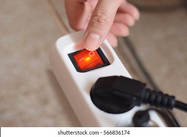 Electricity Usage Saving Power By Turned Off. Human Finger On Red Button On Electro Plug. High Ricing Price To Electrical Energy At Home. Concept Image To Crise For Energy Branch In Europe.