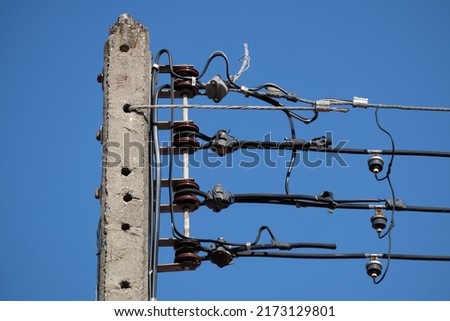 Electrict pole in urban developing country with power line infront of blue sky background