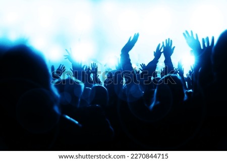 Electrifying energy of a music concert as young, sheering people revel in the beats and rhythms. With hands waving in the air, the crowd radiates pure joy and enthusiasm; party vibes