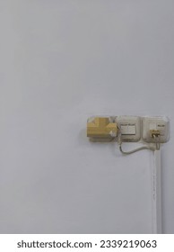 Electrifying Simplicity: Electrical Socket and Plug on a White Wall