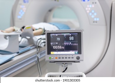 Electrocardiogram In Hospital CT Scan Room. Heart Rate Monitor In Hospital. Process Of CT Scanning Of An Old Patient. Man Receiving A Medical Scan For A Trauma