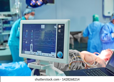 Electrocardiogram in hospital surgery operating emergency room showing patient heart rate with blur team of surgeons background - Powered by Shutterstock