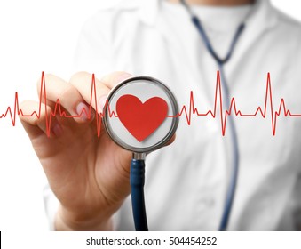 Electrocardiogram, red heart and female hand with stathoscope, closeup. Cardiology concept.