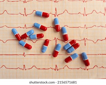 Electrocardiogram with red-blue pills. Medical examination of heart treatment and control of cardiovascular system concept