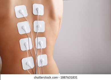 Electrode Stimulating Massage Of The Spine At Home. Medical Procedure For Muscle Tone And Beauty