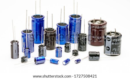 Electrolytic capacitors, many colors and sizes, white background, electronic component concepts