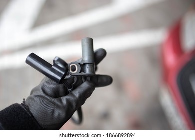 electromagnetic crankshaft position sensor of a car engine in the hands of an auto mechanic.