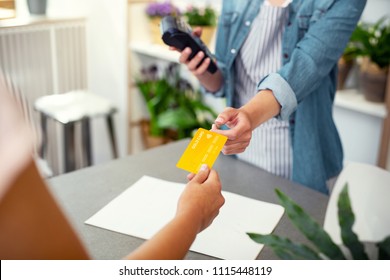 Electronic Banking. Professional Shop Assistant Taking A Credit Card While Making A Payment