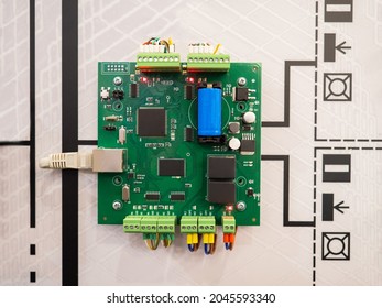 Electronic board. Network cable is connected to PCB. Green computer board. Concept - testing of electronic boards. PCB inspection during production. Computer chip is attached to wall of equipment.