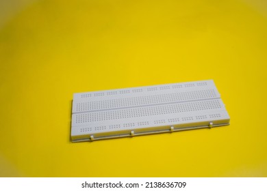 Electronic breadboard isolated on a yellow background. 