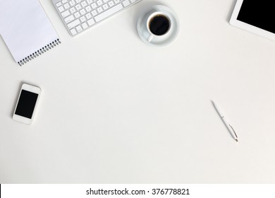 Electronic and Business Items dropped in creative Disorder on white Table Tablet PC Computer Keyboard Telephone Notepad Pen Coffee Cup - Powered by Shutterstock