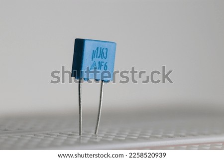 Electronic capacitor on a bread board with a white background 